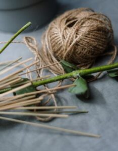 Close-up of twine and flower stems arranged on a table, perfect for DIY projects.