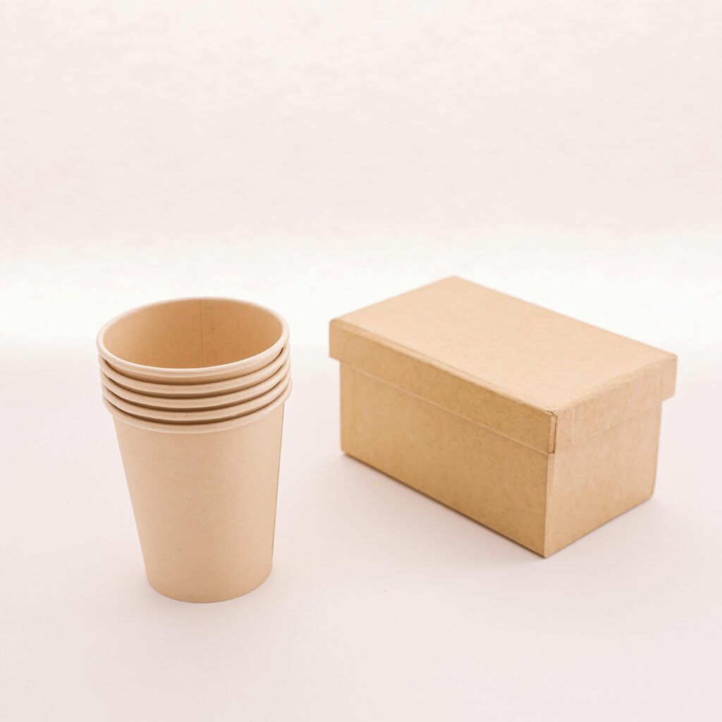 pexels-photo-8015739-8015739 Minimalist photo of cardboard box and cups reflecting sustainability and eco-friendly packaging.